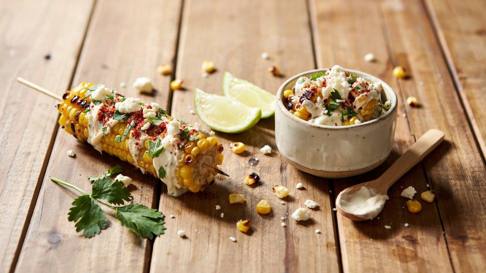 Healthy elote and esquites with Greek yogurt, cotija cheese, chili powder, cilantro, lime, and grilled corn.