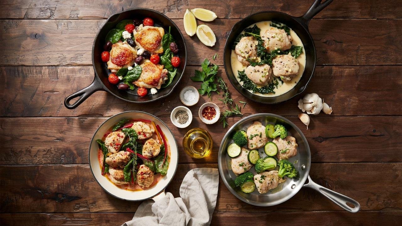 Four delicious chicken and greens skillet variations featuring Mediterranean, creamy garlic, spicy, and low-carb styles arranged on a rustic table.