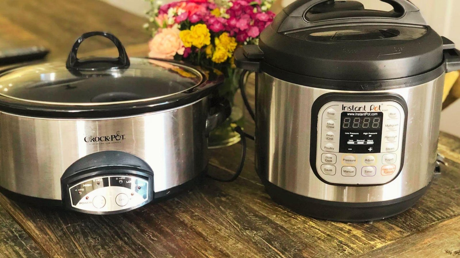 Two stainless steel pressure cookers placed on a wooden table, showcasing their shiny surfaces and sturdy design.
