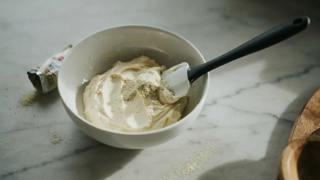Preparing seasoned cream cheese filling for keto pinwheels.