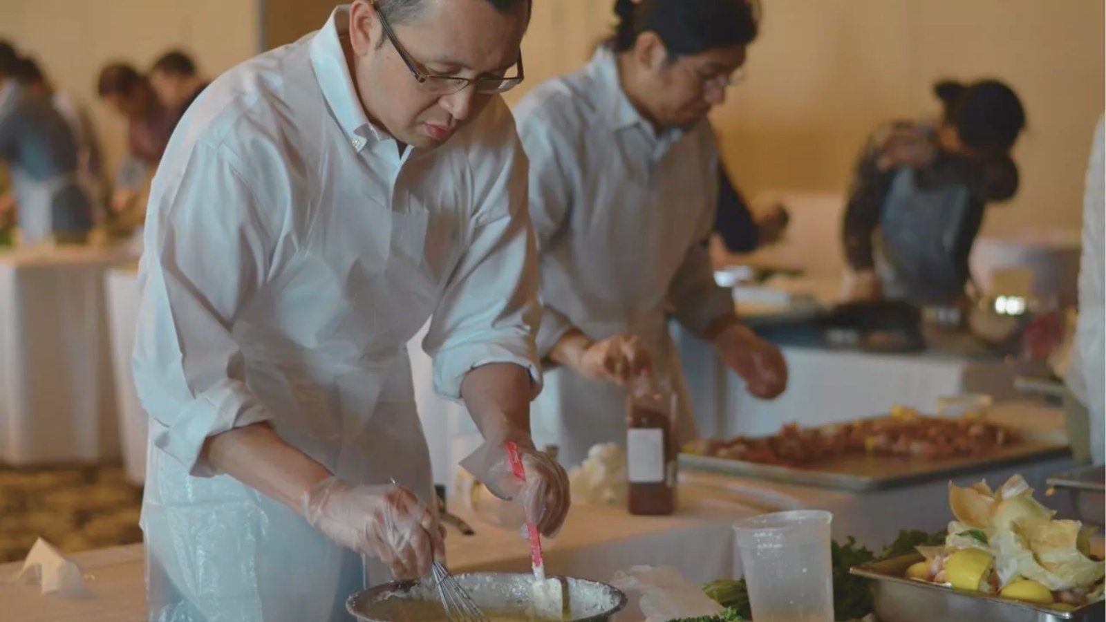 A man wearing a white shirt is engaged in food preparation in a well-equipped kitch
