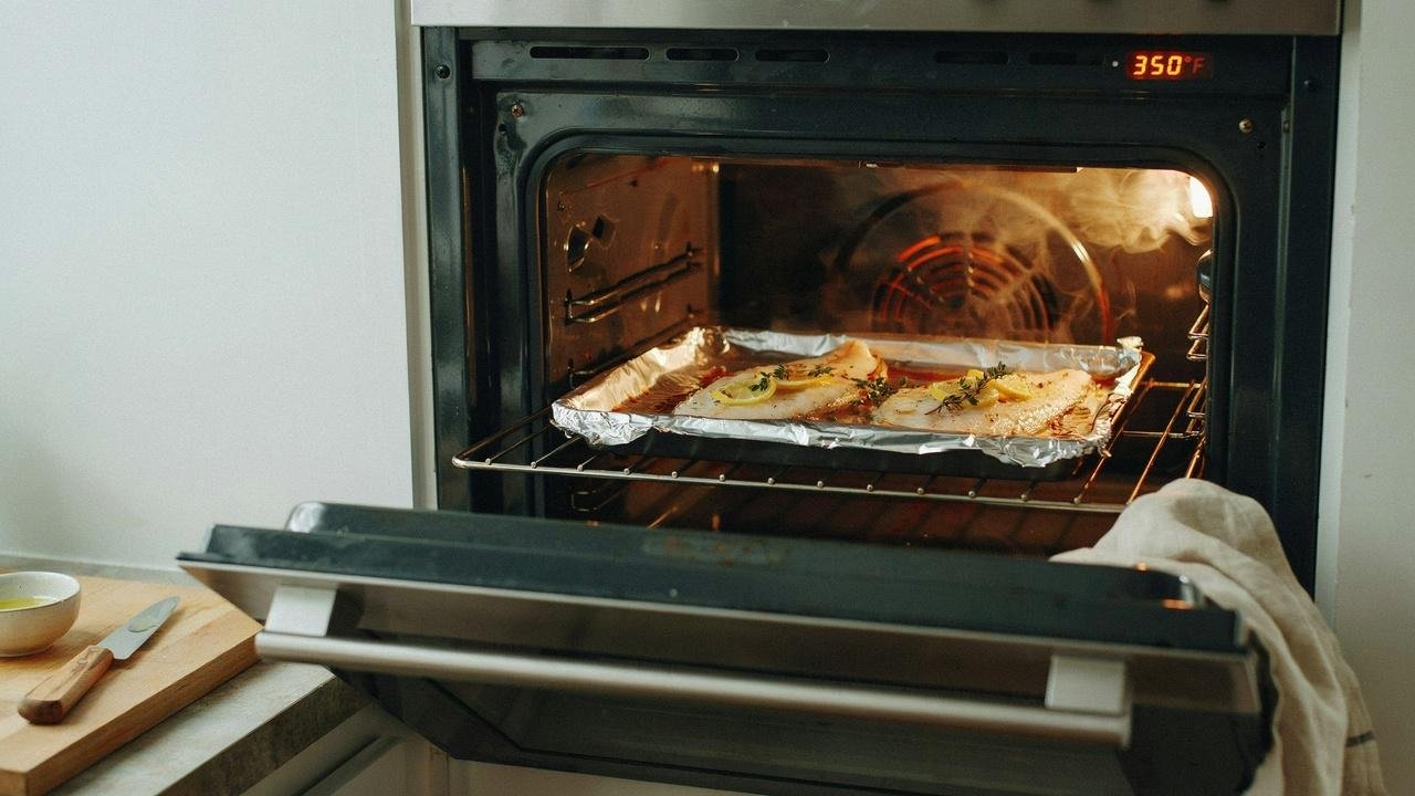 Baked flounder reheating in the oven under foil to retain moisture.