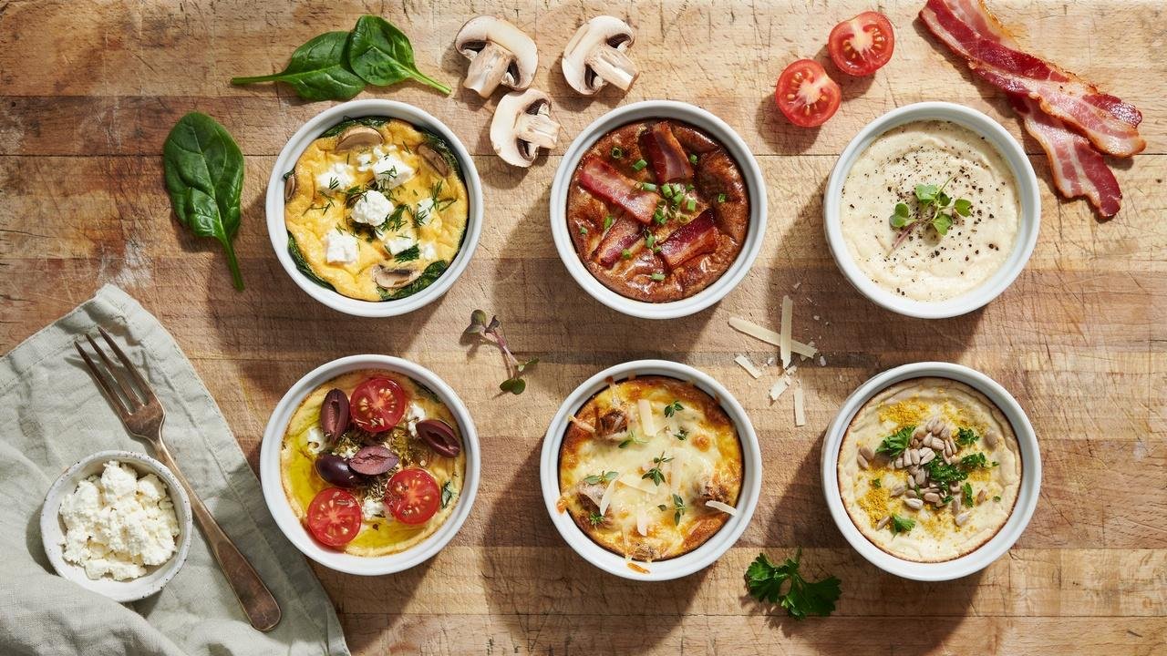 Different variations of spinach mushroom egg bites with cheese, bacon, feta, and herbs.