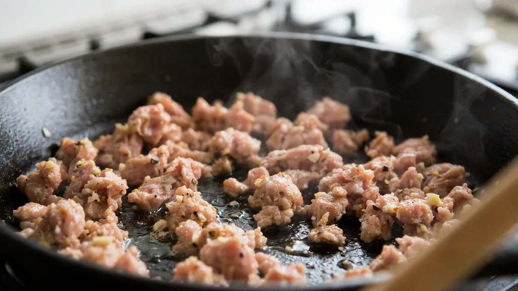 Ground turkey browning in a skillet with onions and olive oil.