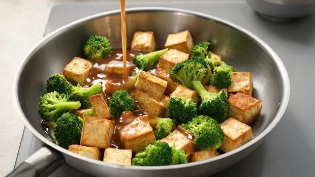 Golden tofu cubes and bright broccoli florets coated in glossy sauce