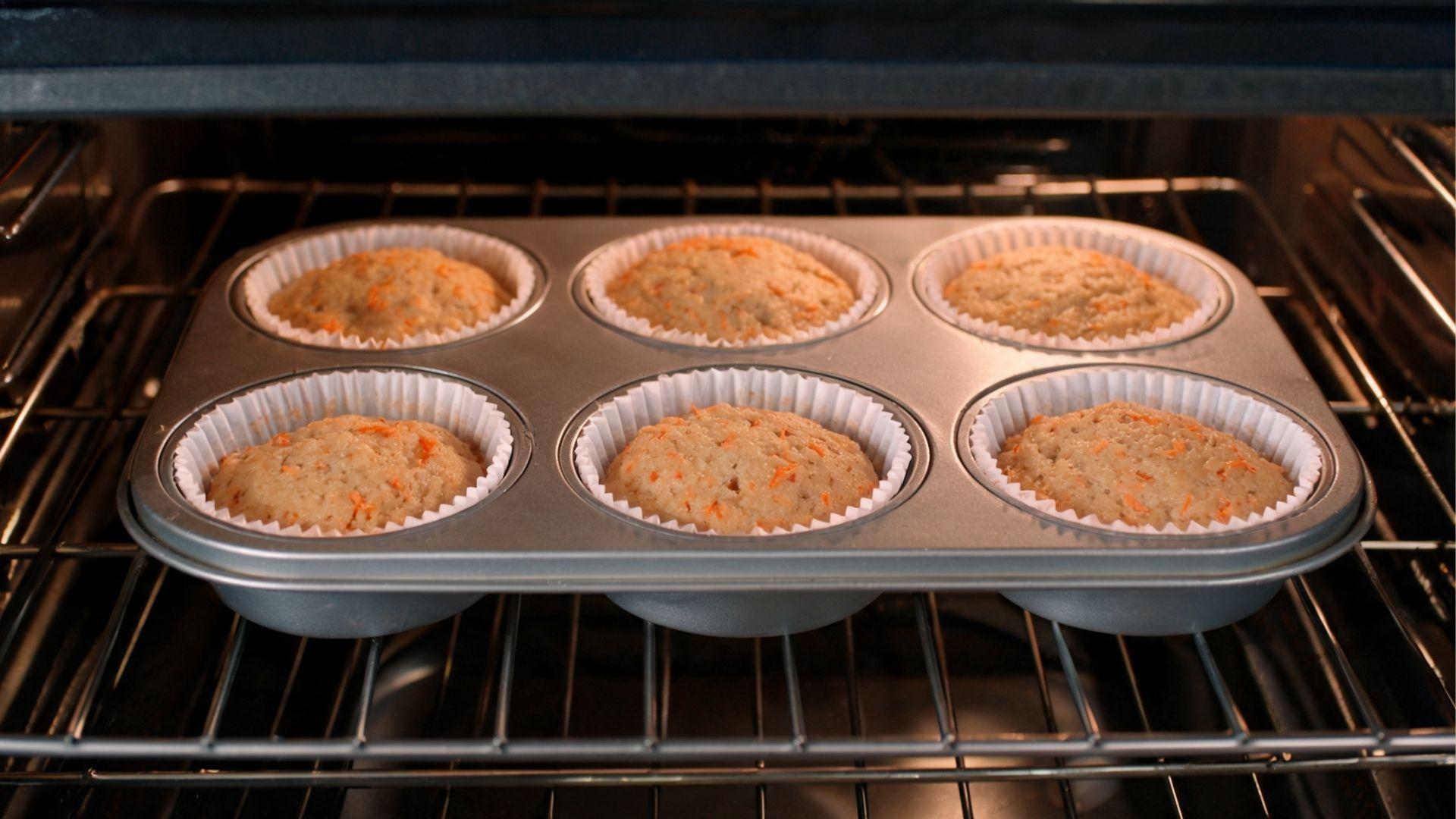 Paper-lined muffin tin filled with carrot muffin batter before baking