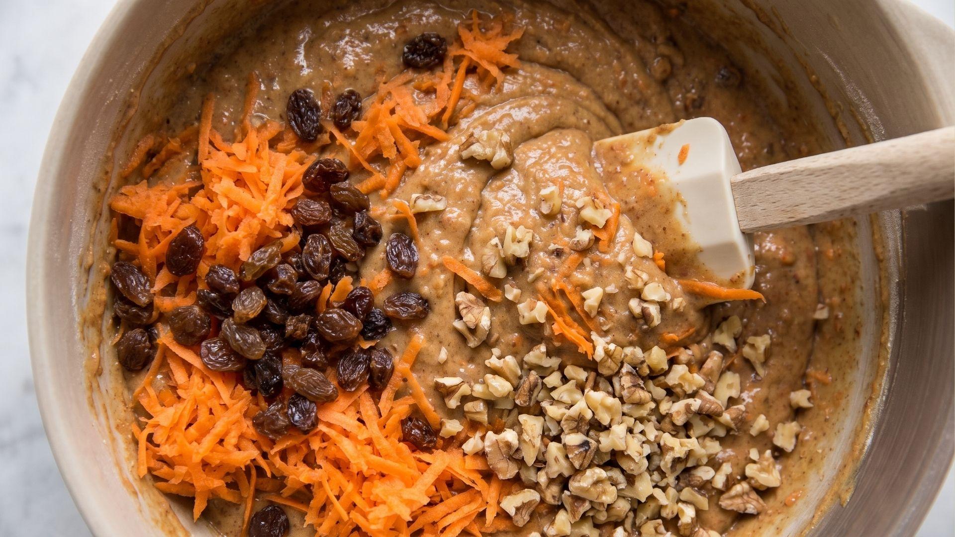 Grated carrots, raisins, and walnuts folded into carrot cake batter