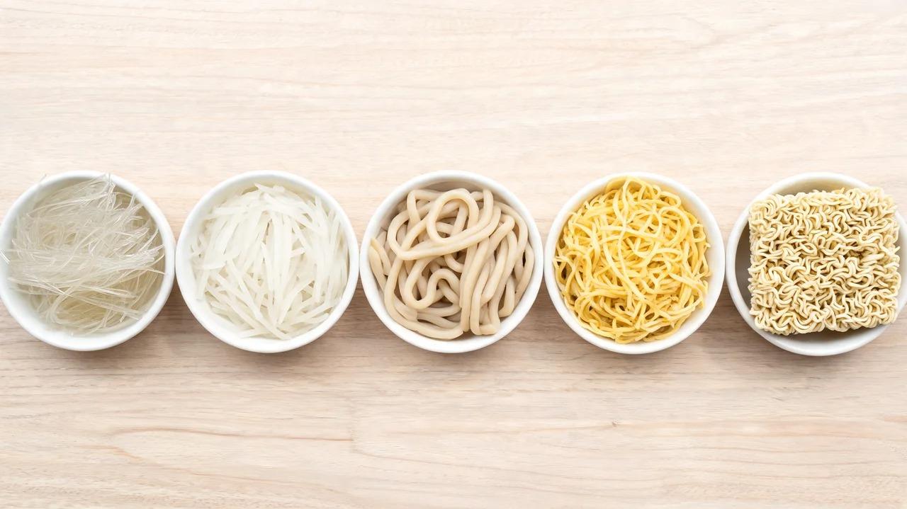 Glass, rice, wheat, egg, and instant Chinese noodles arranged separately