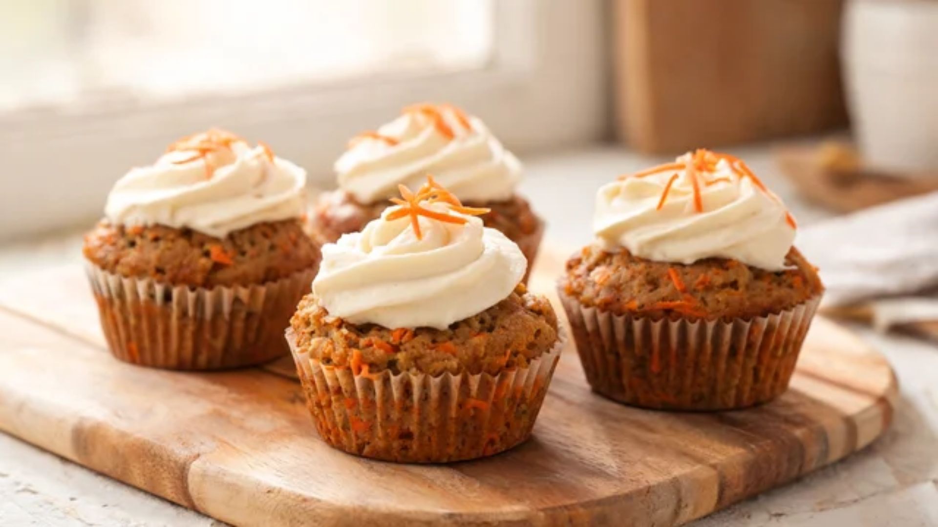 Small batch of carrot cake muffins topped with cream cheese frosting 